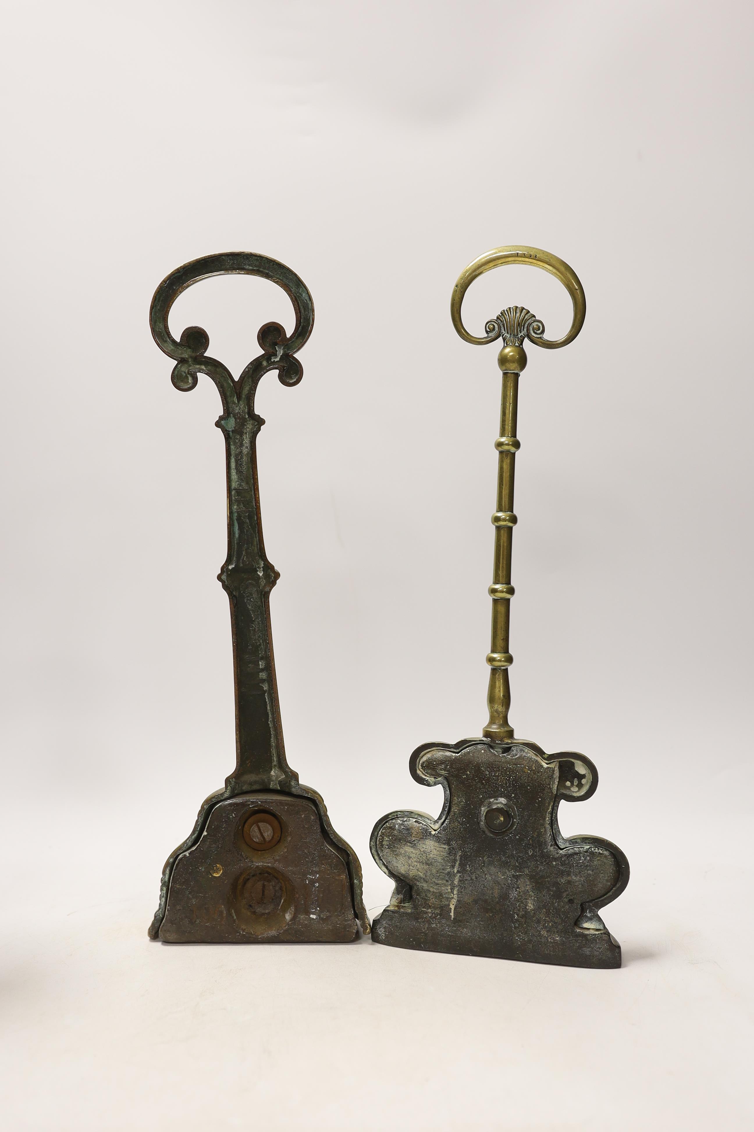 Two 19th century brass door porters and a pair of Gothic Revival brass candlesticks, 37cm (4)